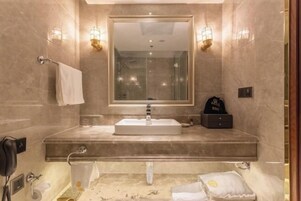 Un baño con un espejo grande, un lavabo y un perchero para toallas.