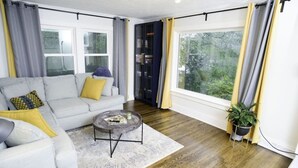 A living room with a sofa, coffee table, and a view of the outdoors.