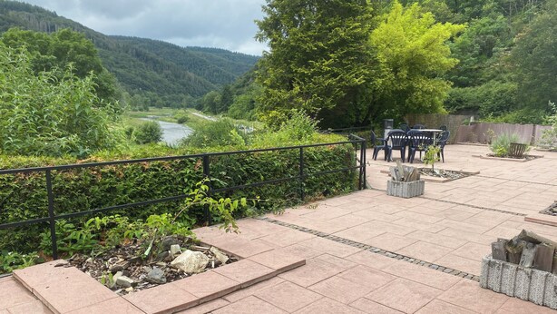 A patio area with a river view, outdoor seating, and a metal railing. - Vacation apartment "Pingo" Address: Bundesstraße 1, 53506 Ahrbrück!  (Ahrbrück)