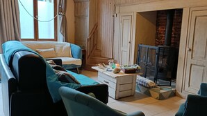 Un salon chaleureux avec un canapé, une table basse et une cheminée.