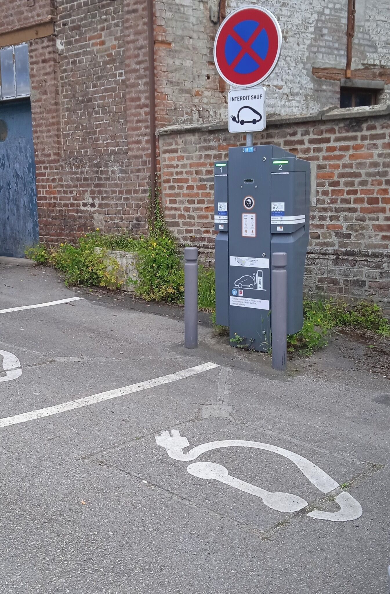 Une zone de stationnement avec un panneau indiquant l’interdiction de se garer, un panneau réservé aux personnes handicapées et un parcmètre.