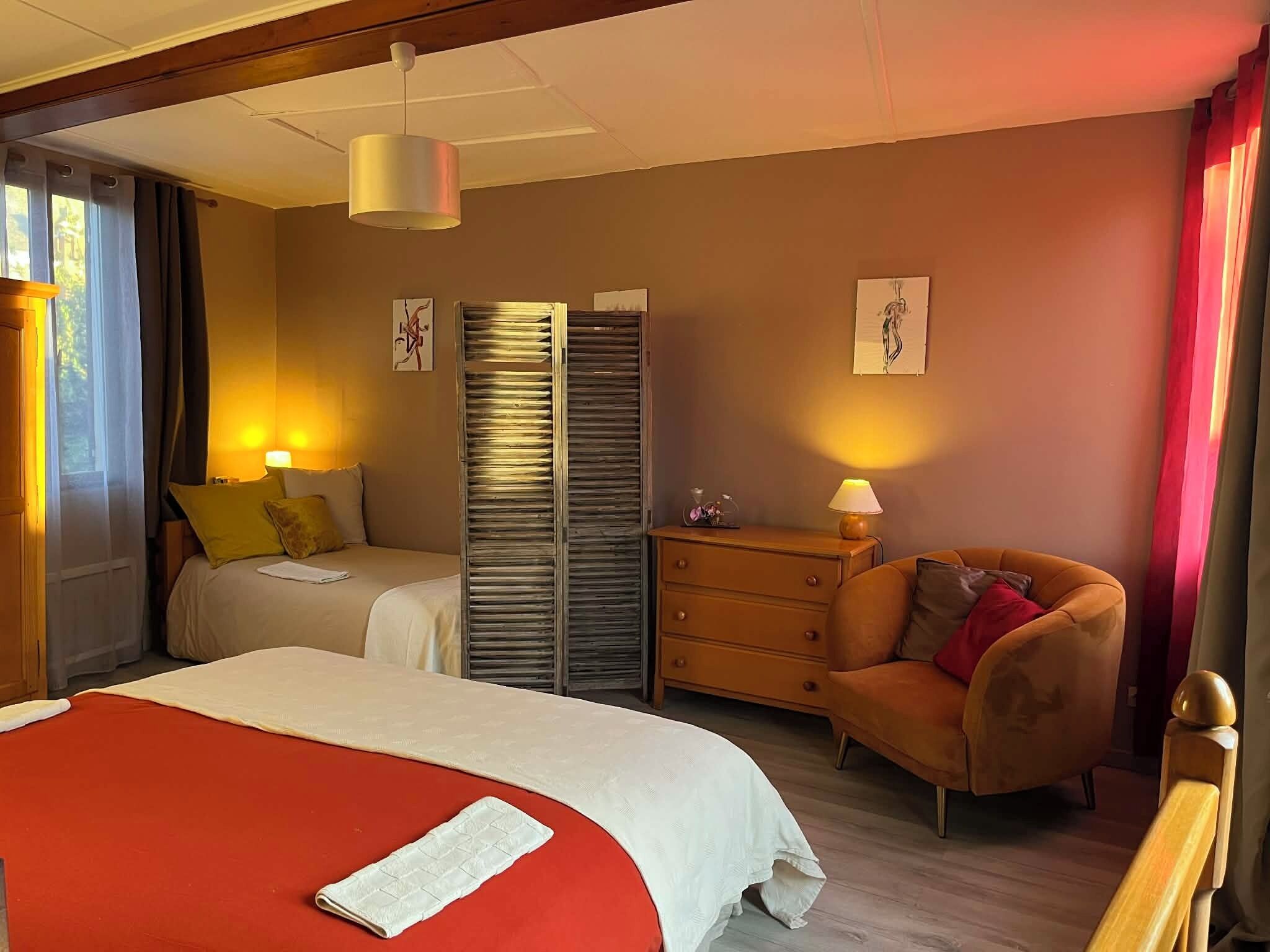 A hotel room with a large bed, a sofa, a dresser, and a wardrobe.