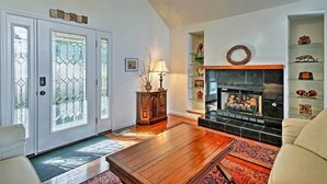 A living room with a fireplace, wooden flooring, and a sofa. - Maple Highlands: Under 1 Mile to Lift! Mountaintop Estate with 2 Scenic Decks (McGaheysville)