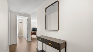 Ein Flur mit einer Konsole, einem Spiegel und einer Tür zu einem anderen Raum.