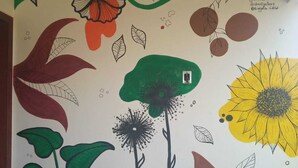 Pared con un mural de flores y hojas estilizadas.