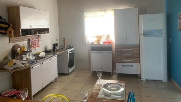 Una cocina compacta con techo de madera, un refrigerador, un microondas y un lavamanos.