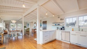 A spacious kitchen with wooden flooring, white cabinetry, and a large island. - Ocean & Mountain View Home - Walk to Trails, Beach, Family Activities (Montara)