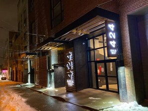Un bâtiment avec un grand panneau lumineux affichant le chiffre « 424 », une marquise en métal et une façade en briques.
