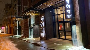 A building with a large illuminated number '424' sign, a metal awning, and a brick facade. - Industrial Loft 5 min to Children’s Hospital, slps 4 (Pittsburgh)