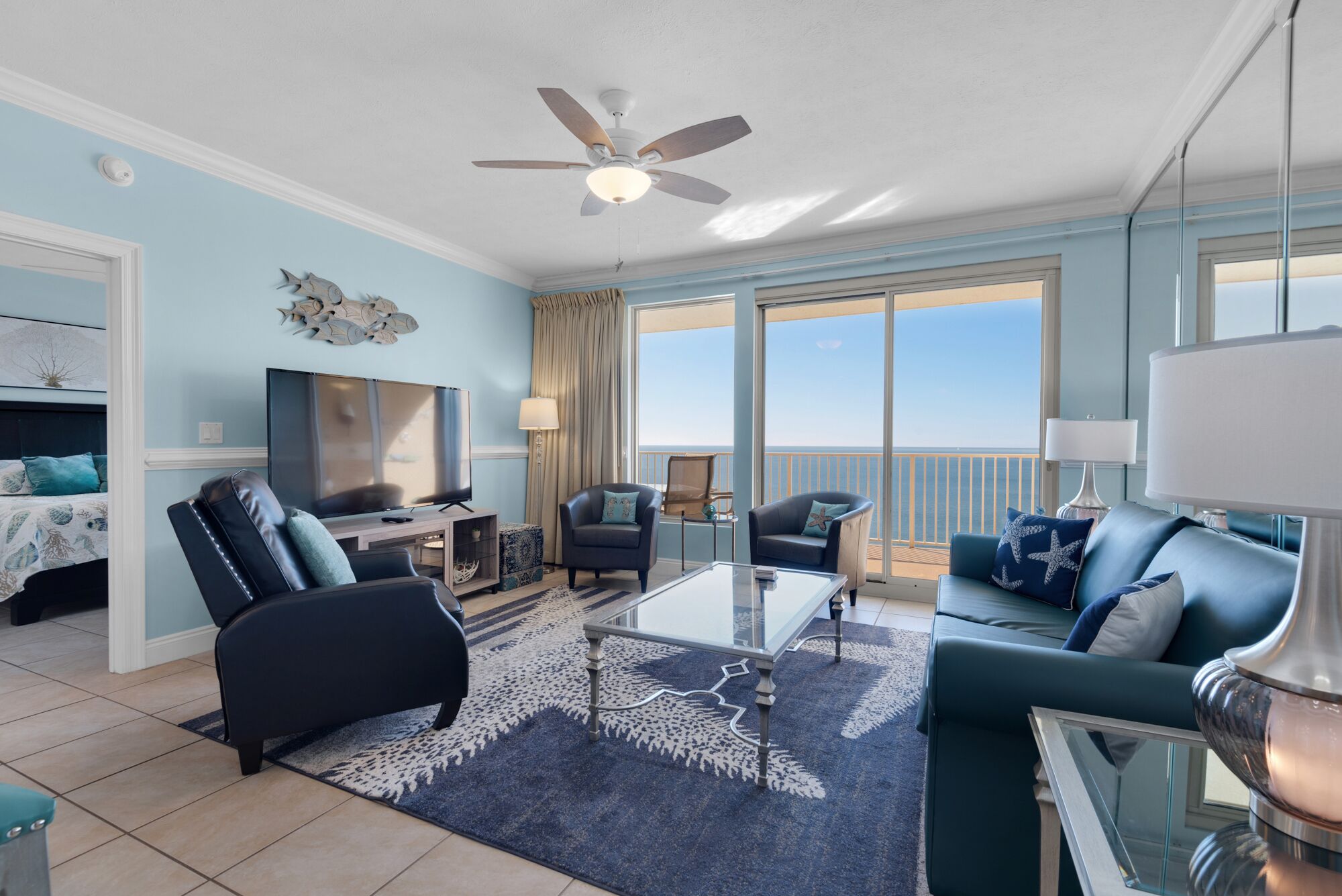 A living room with a TV, two sofas, a coffee table, and a ceiling fan.