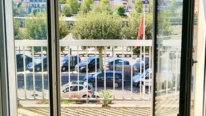 A room with a view of a parking area and a construction site. - TROUVILLE 3 Bdrms 65m2 SPLENDID AND CLEAR VIEW, BATHED IN LIGHT (Trouville-sur-Mer)