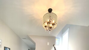 Ein geräumiger Flur mit Treppe, einer Chandelier und einer Sitzbank mit Dekoration.