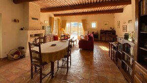 A spacious living area with a dining table, chairs, a sofa, and a fireplace.
