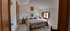 A bedroom with a bed, bedside table, lamp, and window. - Mild hills Villa, on the Tuscany coast with brand new panoramic private pool (Camaiore)