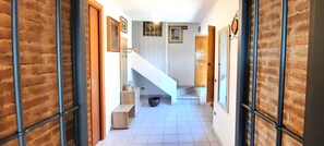 A hallway with a staircase, wooden doors, and tiled flooring. - Mild hills Villa, on the Tuscany coast with brand new panoramic private pool (Camaiore)