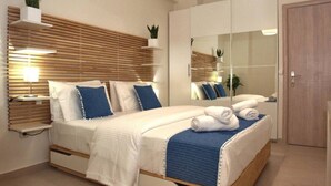 Ein modernes Schlafzimmer mit Bett, Nachttischen, einem Spiegel und einem Kleiderschrank.