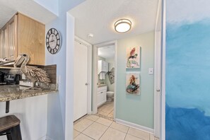 Cozy kitchen area with a granite countertop, wooden cabinet, and decorative bird sculpture.