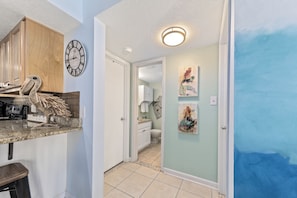 Cozy kitchen area with a granite countertop, wooden cabinet, and decorative bird sculpture.