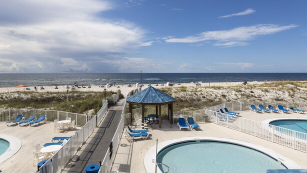 A beachside pool area with lounge chairs and a gazebo overlooking the ocean. - NEWLY RENOVATED CONDO- ON BEACH (Orange Beach)