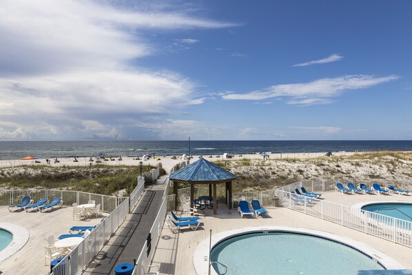 Enjoy ocean views from the resort's deck, featuring lounge chairs and a gazebo, with access to the beach and a swimming pool.