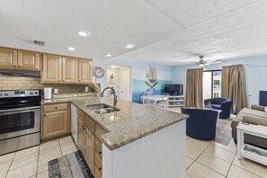 Enjoy cooking and relaxing in this well-equipped kitchen and living area, featuring a stove, oven, and ample workspace.