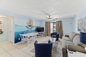 Relax in this stylish living room with a dining area, comfortable sofa, and flat-screen TV.