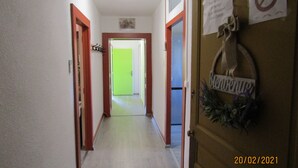 A hallway with a green door at the end, a 'Bienvenido' sign, and a 'No Smoking' sign. - Gîte for 10 people (Prémanon)