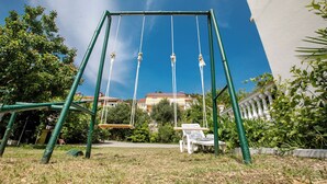 A swing set in a grassy area with a clear blue sky. - Rab Oasis Retreat - 3 Bedroom Apartment (Rab)