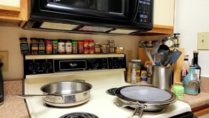 A kitchen with a microwave, stove, and various cooking utensils. - Cozy Condo Near City Dock - Your Perfect Annapolis Getaway! (Annapolis)