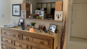 A kitchen with a wooden cabinet, a mirror, and various kitchen items. - Cozy Condo Near City Dock - Your Perfect Annapolis Getaway! (Annapolis)