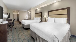 A hotel room with two beds, a desk, a chair, a lamp, and a television. - Best Western Plus McPherson (McPherson)