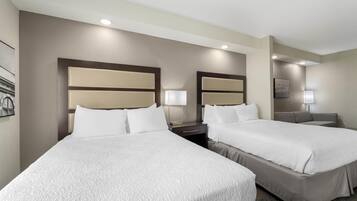Une chambre d’hôtel avec deux lits, un bureau et une chaise.