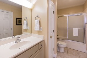 A bathroom with a sink, toilet, and shower. - Treasure Island 0311 (Panama City Beach)