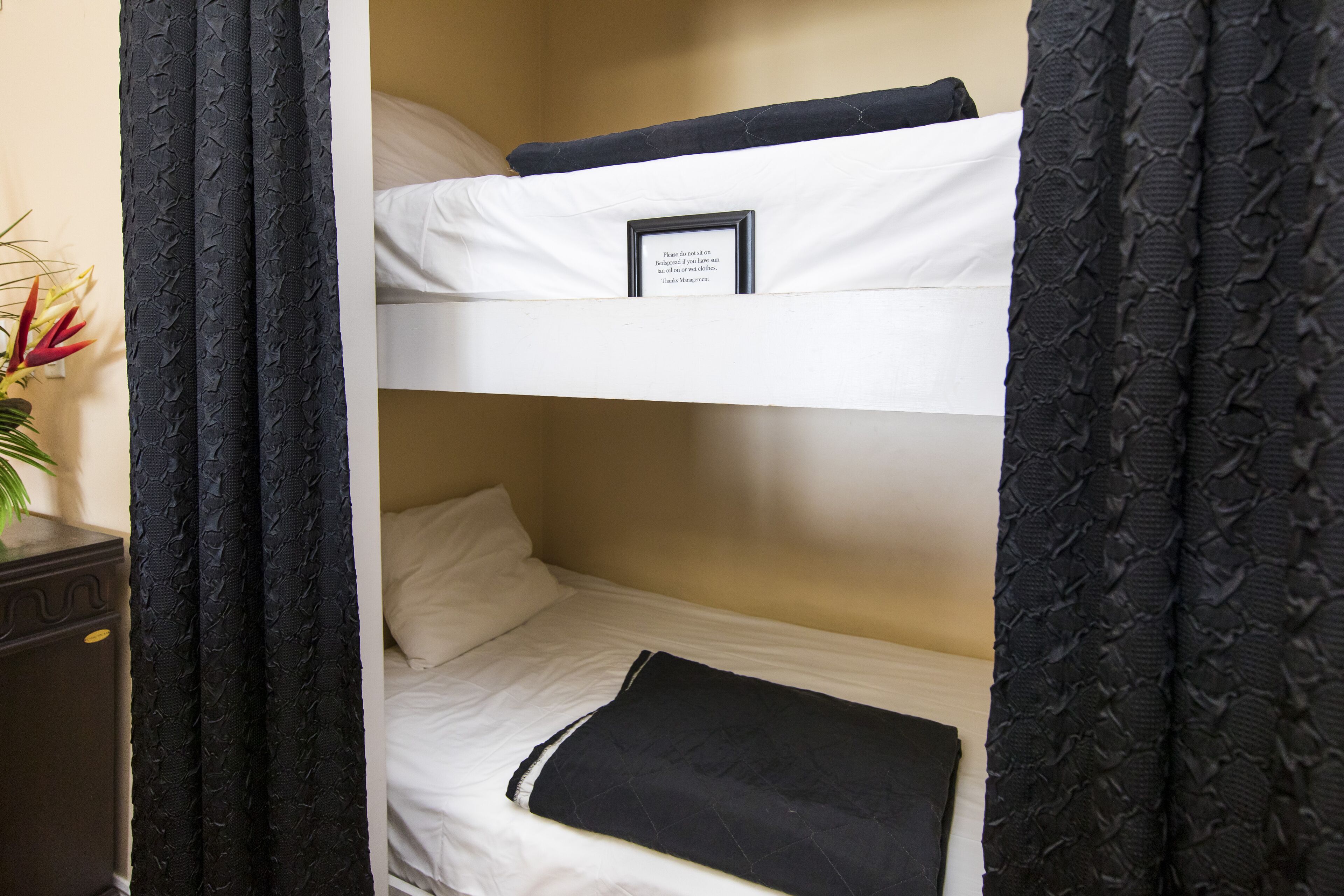Un lit superposé avec un petit mot encadré placé sur le lit du haut.