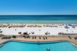 A beach resort with a swimming pool, sun loungers, and umbrellas. - Treasure Island 0510 (Panama City Beach)