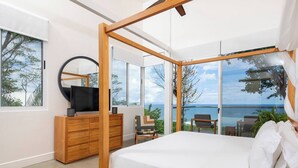 Une chambre moderne avec un grand lit, des meubles en bois, une télévision et une vue sur la mer.