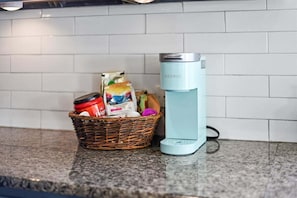 Un bancone cucina con una macchina per il caffè e un cesto di spesa.