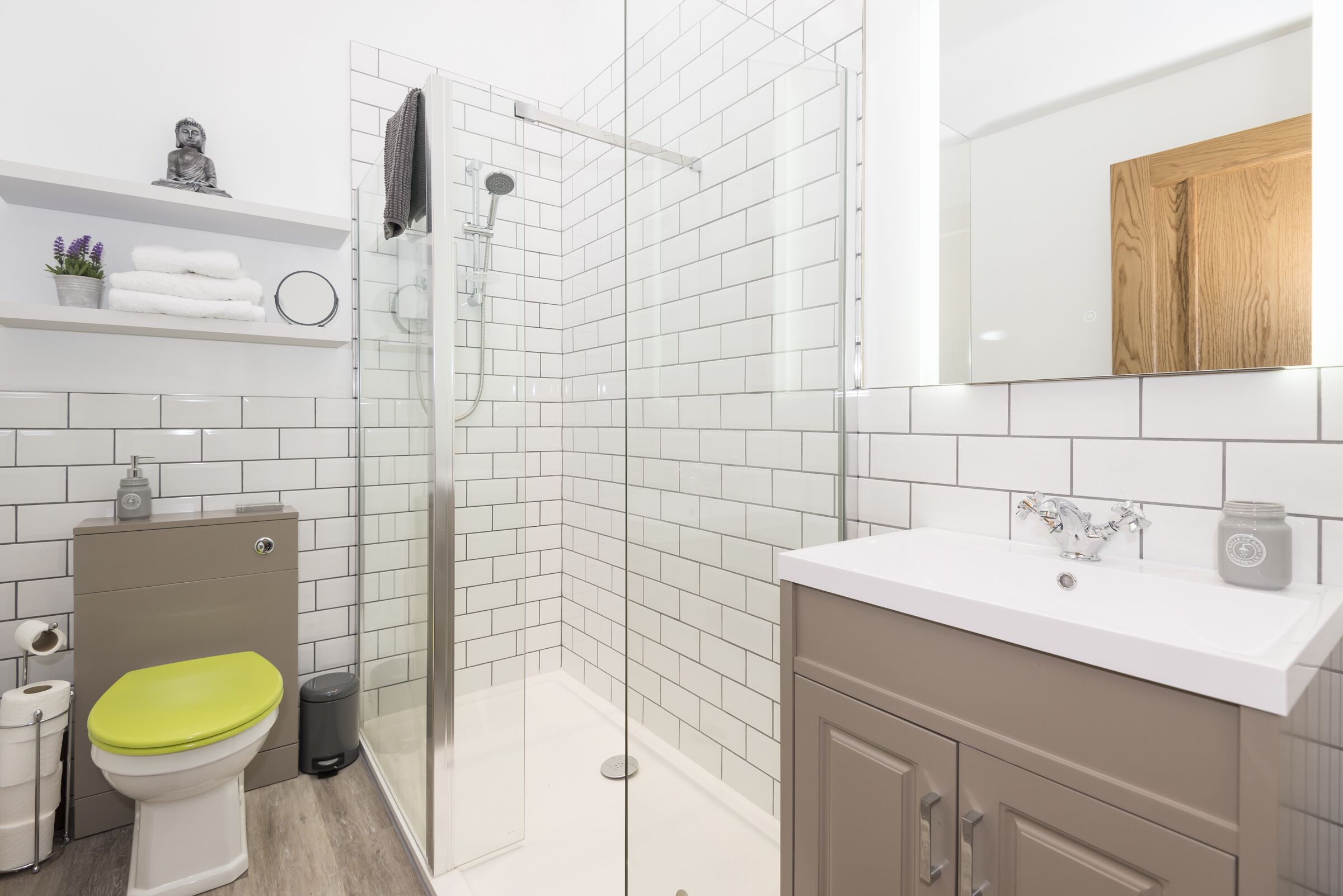 Un baño moderno con inodoro, lavamanos y ducha.
