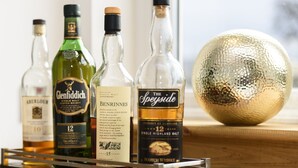 Une sélection de bouteilles de whisky présentées sur un plateau en bois.