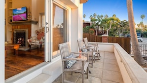 A living room with a fireplace, a television, and a sofa. - Spanish Palms | 3BR Home Steps to Windansea Beach (San Diego)