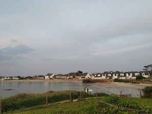A row of white houses with a river in the foreground. - Idéal Vacances, vue Mer, Accès Direct à la Plage (Gâvres)