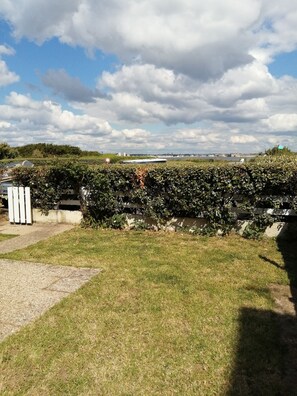 A grassy area with a hedge and a white fence. - Idéal Vacances, vue Mer, Accès Direct à la Plage (Gâvres)