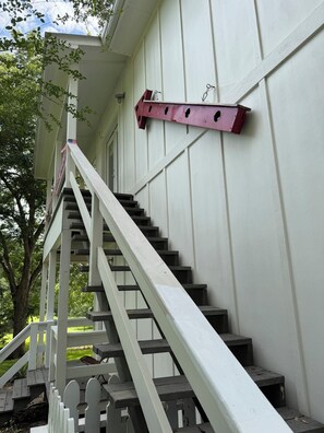 A staircase with a white handrail and steps leading to a porch area.
