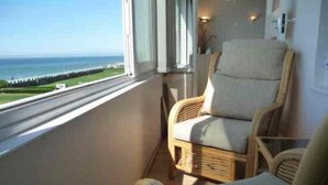 A balcony with wicker furniture, a view of the sea, and a clear sky. - With spectacular sea views the flat is literally across the road from the Beach. (Hove)