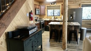 A log cabin kitchen with a central island, wooden cabinets, a refrigerator, and a microwave. - Stunning Views from 3 Level Home, Majestic Sunrise and Mountain Scapes (Pine)