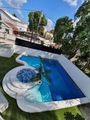 Relax by the pool surrounded by a palm tree and enjoy the hot tub.