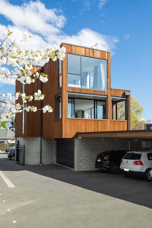 A modern two-story building with large windows and a wooden facade.