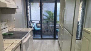 A kitchen with a stove, oven, and a dining area with a table and chairs.