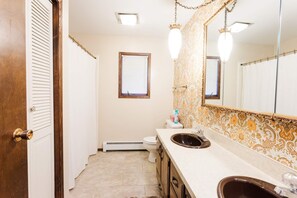 Bathroom features a sink, toilet, and mirror with a decorative frame.