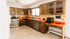 Cozinha com armários de madeira, micro-ondas, forno, lava-louças e geladeira.
